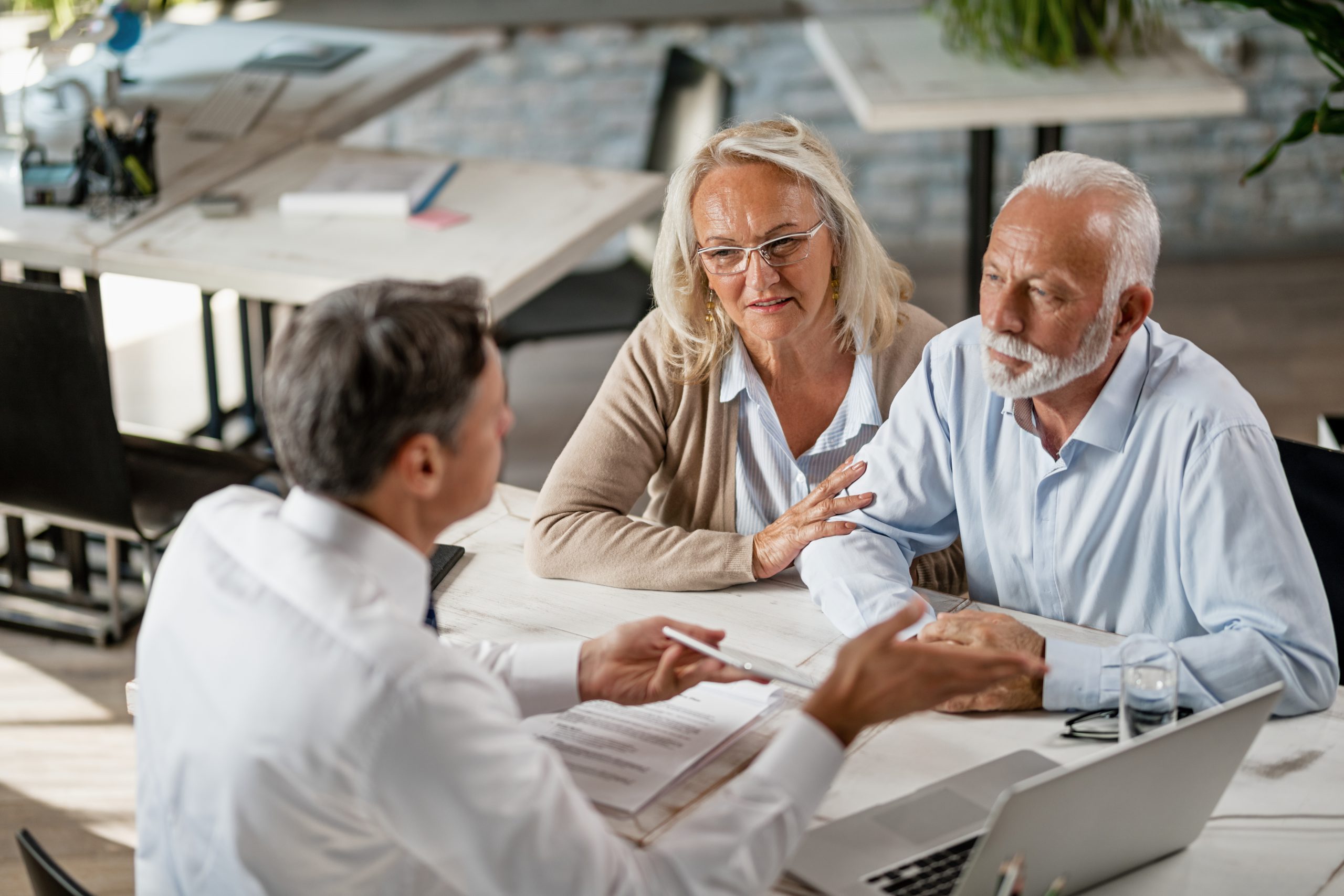 Senior couple talking to agent on a meeting in the office